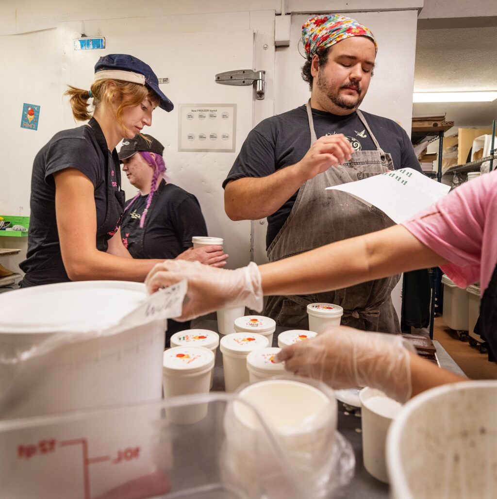 Manager Carter Olson, son of Screamin’ Mimi’s owner Maraline Olson, packages pints of ice cream with the crew in the back of their Sebastopol store Tuesday, Aug. 11, 2026. (John Burgess/The Press Democrat)