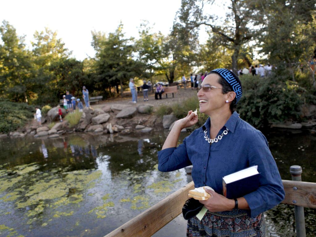 Joslyn Metzger throws bread into Lake Ralphine as a representation of casting away sin during a Rosh Hashanah Tashlich Service organized by Congregation Beth Ami and Congregation Shomrei Torah at Howarth Park in Santa Rosa on Thursday, September 29, 2011. (Beth Schlanker / The Press Democrat)